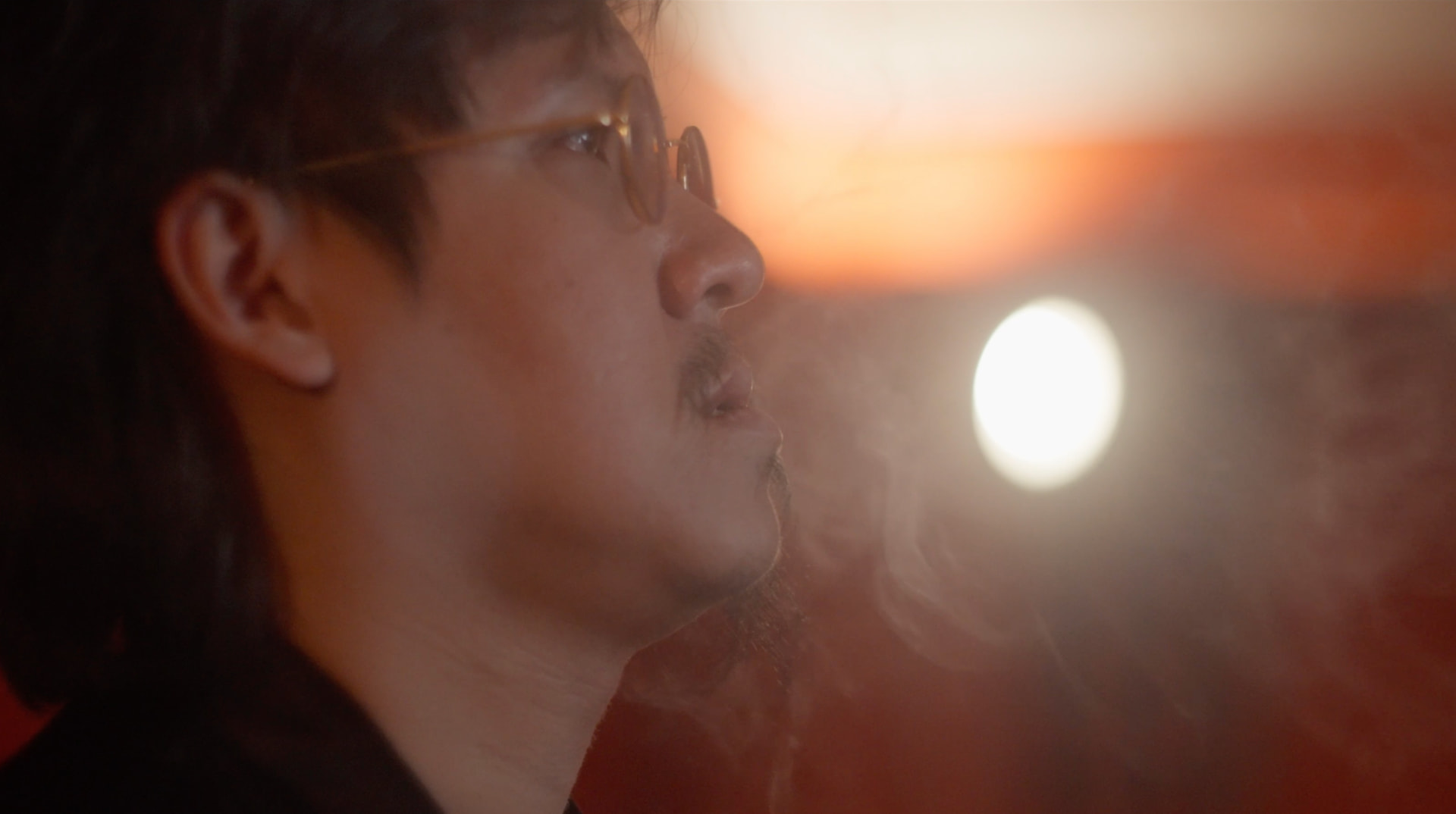 A man in warm light, gazing upward in reflection